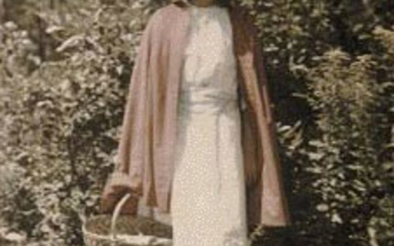 A faded Autochrome, by an unknown photographer, depicting Little Red Riding Hood dressed up for her adventure with the wolf. c. 1910. 5 x 3 1/2" (12.7 x 8.9 cm)