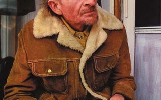 A man with a flushed face wearing a brown coat.