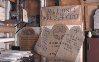 Corner of room with printed documents. One of them says, "All things are difficult before they are easy" in a thin font.