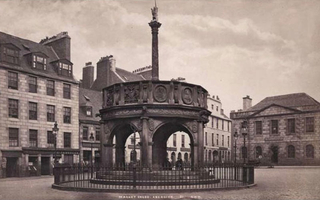 View of a city's street. A circular monument is in the center and buildings make up the background.