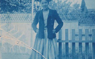 Blue-tinted view of a woman standing in a yard.