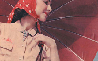 Woman dressed in pink and red holds a red umbrella.