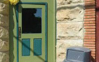 A green and blue door next to a trash can.