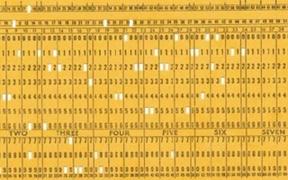 Yellow paper card with punched holes and printed numbers.