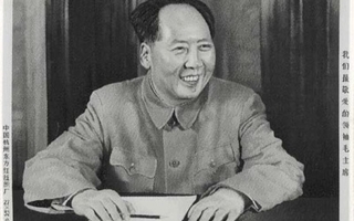 Woven cloth that depicts Chairman Mao smiling as he sits at a table.