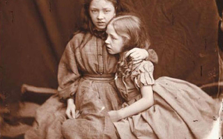 Sisters in dresses sitting together.