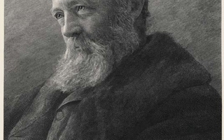 A side view of a man with a white beard and coat.